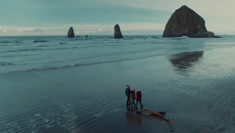 4k-Luftbild-Von-Oregon-Strandmenschen,-Die-Auf-Nassem-Sand-Laufen