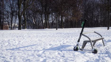 Electric-scooter-abandoned-in-the-park-during-snowy-winter-static-shot-1