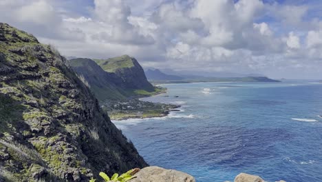 A-wide-shot-of-a-mountain-view-with-deep-blue-ocean-water-that-stretches-to-the-foreground
