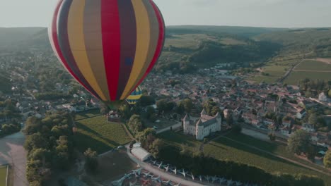 4k-Antenne-Zwei-Heißluftballons-In-Der-Luft-Und-Flugplatz-Im-Hintergrund