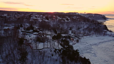 Aerial---Flying-over-houses-on-the-coast-of-the-St-Lawrence-river-at-sunset