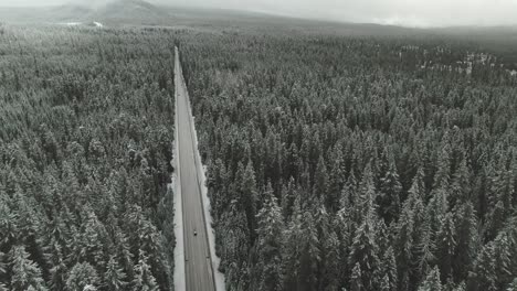 4k-Aerial-Country-road-in-snowy-forest-Drone-tilt-down-+-truck-right-to-left