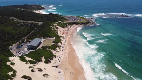 Drohnen-Luftaufnahme-Des-Soldaten-Strand-Surfclubs-Mit-Riff-Des-Pazifischen-Ozeans-Und-Sandküstenlandspitze-Zentralküste-Norah-Head-Nsw-Australien-4k