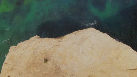4k-Aerial-high-cliff-on-blue-ocean-Drone-overhead-+-dolly-out-shot