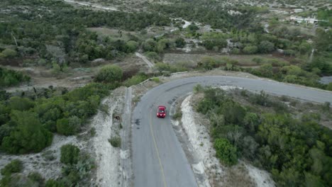 AERIAL---Car-driving-down-many-curves-in-hill-road,-Tamaulipas,-Mexico,-tracking