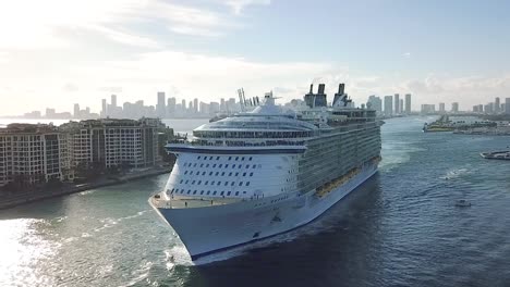 Aerial-shot-of-Huge-luxury-cruise-ship-leaving-Port-of-Miami-at-sunset,-Miami-beach,-Flordia-USA-HD