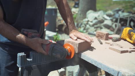 Construction-Worker-Sawing-And-Shaving-Bricks-With-Electric-Power-Tools-On-Sunny-Day,-Slow-Motion