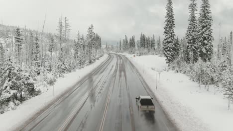 4k-Aerial-country-road-in-snow-with-traffic-Drone-dolly-out-shot