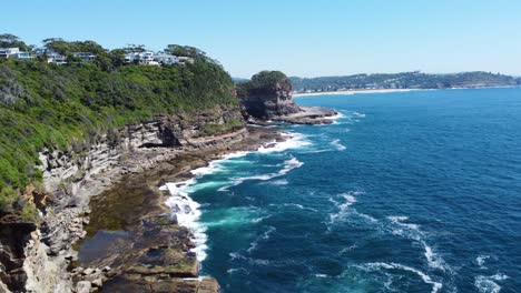 Aerial-drone-shot-of-Pacific-Ocean-landscape-headland-houses-nature-Avoca-tourism-Winnie-Bay-Copacabana-Central-Coast-NSW-Australia-4K