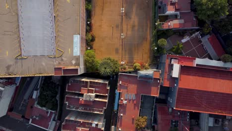 Top-View-of-Tennis-Sports-Club-Surrounded-by-Several-Houses-and-a-Parking-Lot-in-the-Morning,-Mexico-City