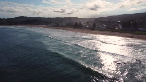 Luftdrohne-Malerische-Landschaftsaufnahme-Von-North-Avoca-Beach-Mit-Surfern,-Die-Auf-Nachmittagswellen-Warten,-Zentrale-Küste-Von-NSW,-Australien-4k