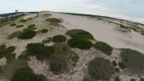 A-Top-view-of-barren-desert-trails,-sand-dunes,-and-steep-slopes-with-small-bushy-foliage-located-in-Dune-Shacks-Trail-in-Provincetown,Cape-Cod,Massachusetts