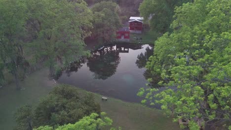Aerial---Reflection-on-small-lake-on-a-ranch,-Nuevo-León,-Mexico,-circle-pan-reveal
