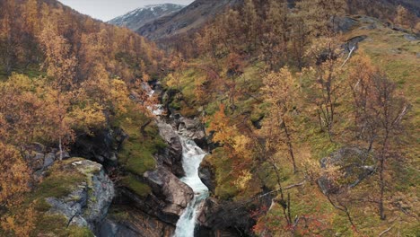 Aerial-view-of-the-wild-river-cascading-through-the-narrow-canyon-in-the-autumn-valley