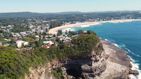 Aerial-Drone-shot-landscape-scenic-view-of-Winnie-Bay-Avoca-headland-with-cave-and-bushland-Copacabana-Central-Coast-suburb-NSW-Australia-4K