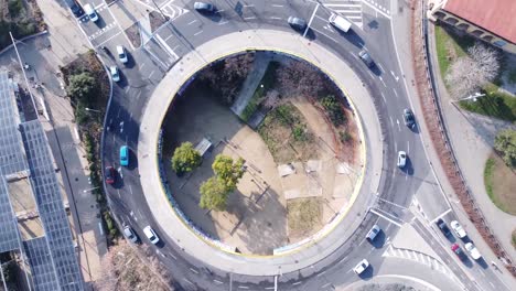 Aerial-view-circling-above-traffic-driving-around-Barcelona-ring-road-roundabout