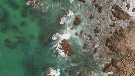 4k-Aerial-rocky-coast-with-turquoise-water---Drone-overhead-shot
