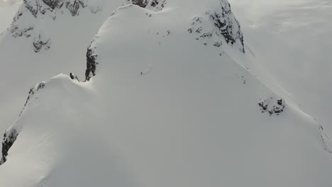 Esquiador-Bajando-Por-La-Cara-De-Una-Montaña-Polvorienta-En-Las-Montañas-De-British-Columbia,-Canadá