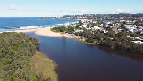 Aerial-drone-shot-across-Wamberal-lagoon-lake-with-residential-housing-Terrigal-beach-nature-travel-tourism-Central-Coast-NSW-Australia-4K
