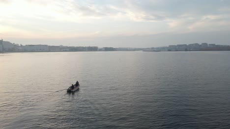 Zwei-Fischer-Sitzen-In-Ihrem-Boot-Auf-Dem-Weg-Nach-Karlskrona,-Schweden-An-Einem-Schönen-Bewölkten-Tag-Kurz-Vor-Sonnenuntergang