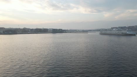 Volando-Sobre-El-Agua-A-La-Ciudad-Naval-De-Karlskrona,-Suecia-En-Un-Día-Nublado-Con-Barcos-Alrededor