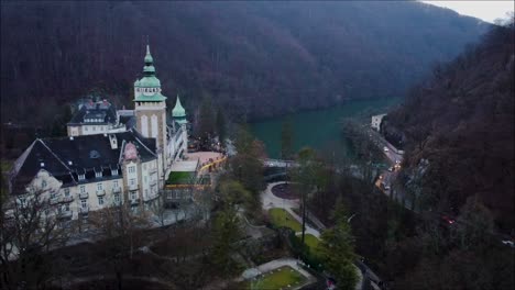 Drone-shot-of-a-hungarian-castle-with-the-view-of-a-lake-in-autumn