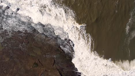 Aerial-drone-Bird's-eye-view-landscape-shot-of-bodyboarder-on-coastal-reef-waves-stormwater-Newcastle-NSW-Australia-4K