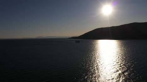 Stunning-aerial-shot-of-a-ferry-sailing-at-sunset-on-the-Howe-Sound-in-British-Columbia,-Canada