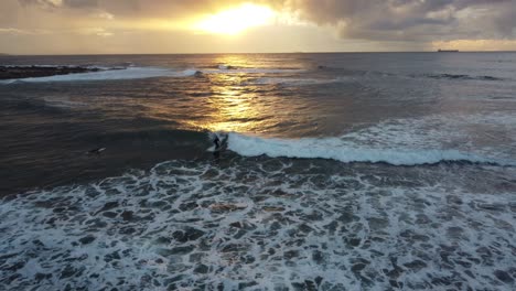 Luftdrohnenaufnahme-Des-Surfers-Am-Morgen,-Der-Auf-Einer-Meereswelle-Reitet,-Mit-Einer-Schönen-Reflexion-Des-Sonnenaufgangs,-Reisen,-Tourismus,-Pazifik,-NSW,-Zentralküste,-Australien-4k