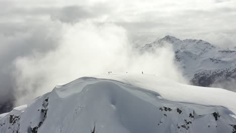 Very-cinematic-shot-of-backcountry-skiers-on-the-top-of-a-snowy-mountain-in-British-Columbia