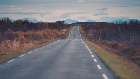 A-narrow-asphalt-road-in-the-autumn-tundra-landscape