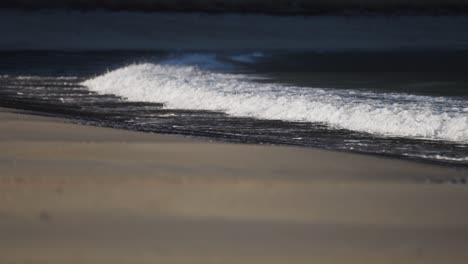 Waves-rolling-on-the-sandy-shore.-Slow-motion