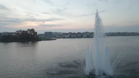 Footage-of-the-beautiful-fountain-standing-in-the-middle-of-the-water-in-the-naval-city-of-Karlskrona,-Sweden-on-a-cloudy-day-when-the-sun-is-about-to-set-1