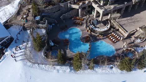 People-Skiing-near-a-luxury-resort-with-a-pool-and-sitting-area-in-Deer-Valley-Park-City-Utah
