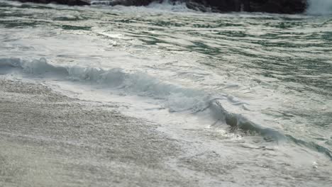A-close-up-shot-of-the-long-waves-spilling-on-the-sandy-beach