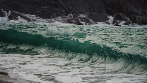 Mächtige-Wellen-Schlagen-Auf-Die-Felsen-Und-Schwappen-über-Das-Sandige-Ufer