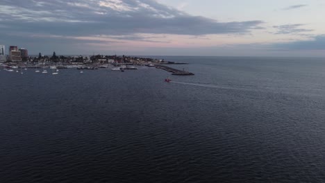 Cinematic-view-of-fishing-boat-in-vast-ocean,-approaching-port-of-Punta-del-Este-city