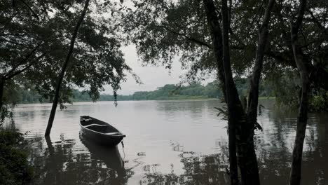 Einsames-Holzboot,-Das-Auf-Einem-Ruhigen-See-Im-Amazonas-Regenwald-Von-Ecuador-Schwimmt