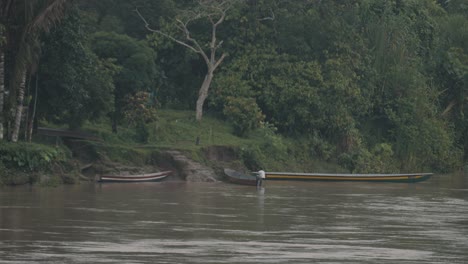 Man-Mooring-Wooden-Boat-On-The-Shore-Of-Amazon-River---wide