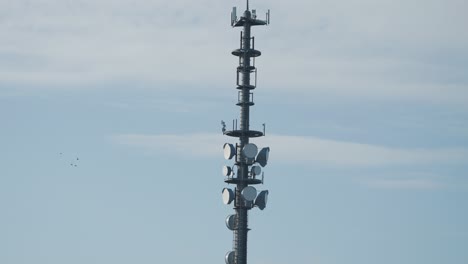 5g-Antennenturm-Gegen-Den-Blauen-Himmel.-Zeitlupe,-Schwenk-Folgen