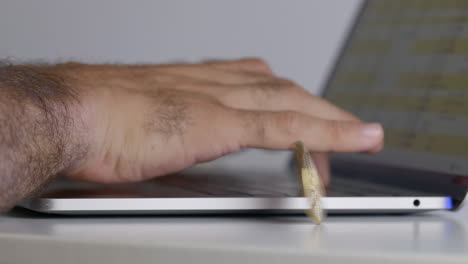 A-mans-hand-typing-on-a-laptop-with