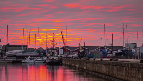 Dramatic-red-sunrise-over-harbor-with-reflection-in