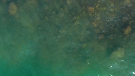 Shimmering-beach-water-appears-green-from-above