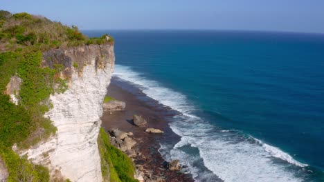 Majestic-cliff-standing-tall-beside-coastline-of-beach