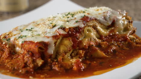 Lasagna-on-white-plate-pooling-bolognese-sauce-slider