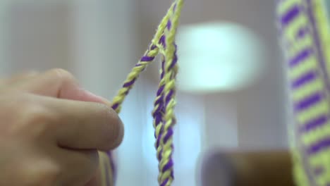 Hand-weaving-of-braids-using-yellow-and-purple