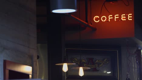 Camera-focusing-on-red-neon-coffee-sign-on