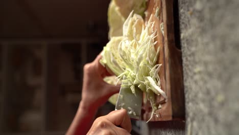 Vertical-Shot-Of-White-Cabbage-Being-Chopped-On