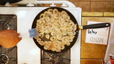 Stirring-prawns-as-the-simmer-in-a-skillet