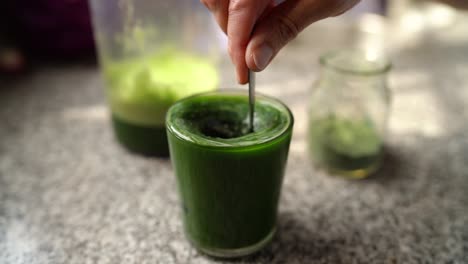 Adding-Spirulina-To-Glass-Of-Healthy-Green-Vegetable